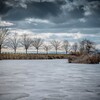 Winterlandschaft – See mit Baeumen