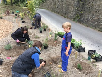 Ob klein ob groß: Alle waren neugierig und wollten mehr über die Anbaumethode erfahren Zwei Frauen und Junge pflanzen Pflanzen in Boden