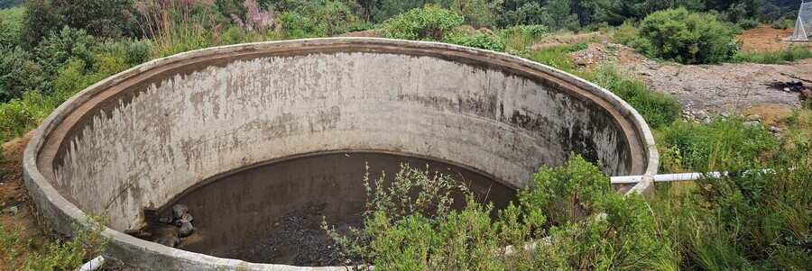 Eines der von Naturefund gebauten Wasserbecken Ausgetrocknetes Wasserbecken in Bolivien vor dem Panorama der Anden